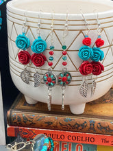 Load image into Gallery viewer, These Southwester Style Silver Feather Light Dainty Beaded Earrings are richly adorned with turquoise, bright red and dark green, and feature silver plated feather charms for a fun, dynamic effect. A perfect match for any Chingona Carbrona, La India Princess, Fierce Goddess Warrior, or Tribal Pattern look.  Measurements: 3” in length
