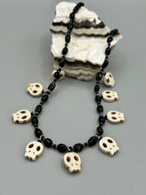 Load image into Gallery viewer, This black and white Goth-style necklace displays a series of shimmering dark-toned glass beads that gracefully encircle the neck and feature hanging skull-shaped beads. A powerful, bewitching and audacious piece of jewelry.  Measurements: 19 1/4&quot;
