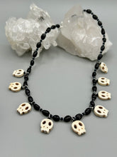 Load image into Gallery viewer, This black and white Goth-style necklace displays a series of shimmering dark-toned glass beads that gracefully encircle the neck and feature hanging skull-shaped beads. A powerful, bewitching and audacious piece of jewelry.  Measurements: 19 1/4&quot;
