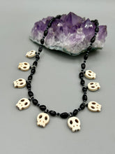 Load image into Gallery viewer, This black and white Goth-style necklace displays a series of shimmering dark-toned glass beads that gracefully encircle the neck and feature hanging skull-shaped beads. A powerful, bewitching and audacious piece of jewelry.  Measurements: 19 1/4&quot;
