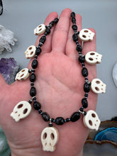 Load image into Gallery viewer, This black and white Goth-style necklace displays a series of shimmering dark-toned glass beads that gracefully encircle the neck and feature hanging skull-shaped beads. A powerful, bewitching and audacious piece of jewelry.  Measurements: 19 1/4&quot;
