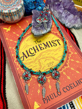 Load image into Gallery viewer, This two-stranded necklace features a vibrant Southwest-inspired design. Hand-beaded turquoise, bright red, and dark green colors, along with silver-plated feather charms, add dynamic movement to the piece. An ideal set for chingona guerrera carbonas, la India princesses, warrior cosplay, and other native-inspired looks.  Measurements:  Necklace is 15” adjustable up to 18" in length
