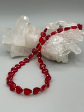 Load image into Gallery viewer, This ruby red heart-shaped glass beaded necklace features a shimmery, translucent finish and a lobster claw clasp.  Measurements:    Necklace is 18 1/2&quot; in length
