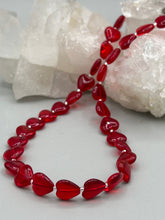 Load image into Gallery viewer, This ruby red heart-shaped glass beaded necklace features a shimmery, translucent finish and a lobster claw clasp.  Measurements:    Necklace is 18 1/2&quot; in length
