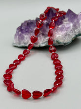 Load image into Gallery viewer, This ruby red heart-shaped glass beaded necklace features a shimmery, translucent finish and a lobster claw clasp.  Measurements:    Necklace is 18 1/2&quot; in length
