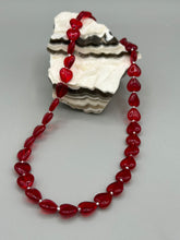 Load image into Gallery viewer, This ruby red heart-shaped glass beaded necklace features a shimmery, translucent finish and a lobster claw clasp.  Measurements:    Necklace is 18 1/2&quot; in length
