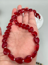 Load image into Gallery viewer, This ruby red heart-shaped glass beaded necklace features a shimmery, translucent finish and a lobster claw clasp.  Measurements:    Necklace is 18 1/2&quot; in length
