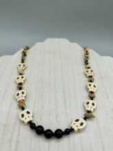 Load image into Gallery viewer, This skully necklace is full of neutral tones and is adorned with natural black obsidian and bamboo chips, as well as small glass beads. It has a unique design that creates a striking silhouette across the wearer&#39;s neck. An ideal statement piece for bold fashion enthusiasts.   Measurements:  Necklace - 19 1/4&quot;
