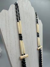 Load image into Gallery viewer, This two-strand necklace features a selection of natural black obsidian stone, hematite, bone, and glass beads. This neutral-hued accessory enhances any ensemble.  Measurements:   Necklace is 29” in length, can be adjusted up to 30&quot; in length  
