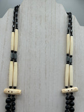 Load image into Gallery viewer, This two-strand necklace features a selection of natural black obsidian stone, hematite, bone, and glass beads. This neutral-hued accessory enhances any ensemble.  Measurements:   Necklace is 29” in length, can be adjusted up to 30&quot; in length  
