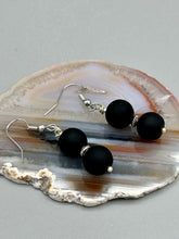 Load image into Gallery viewer, These two-bead flat matte black glass earrings are perfect for any look. With their subtle yet elegant design, they are a great accessory for any closet. 1 1/4” in length

