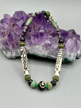 Load image into Gallery viewer, This exquisite necklace features natural ruby zoisite, snowflake obsidian, turquoise magnesite, bone, glass and metal beads, offering a variety of sizes, shapes, textures, and colors.
