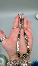 Load image into Gallery viewer, This exquisite necklace features natural ruby zoisite, snowflake obsidian, turquoise magnesite, bone, glass and metal beads, offering a variety of sizes, shapes, textures, and colors.
