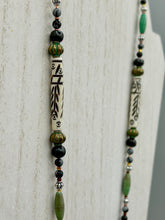 Load image into Gallery viewer, This exquisite necklace features natural ruby zoisite, snowflake obsidian, turquoise magnesite, bone, glass and metal beads, offering a variety of sizes, shapes, textures, and colors.
