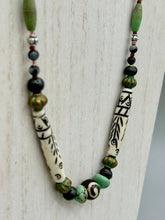 Load image into Gallery viewer, This exquisite necklace features natural ruby zoisite, snowflake obsidian, turquoise magnesite, bone, glass and metal beads, offering a variety of sizes, shapes, textures, and colors.
