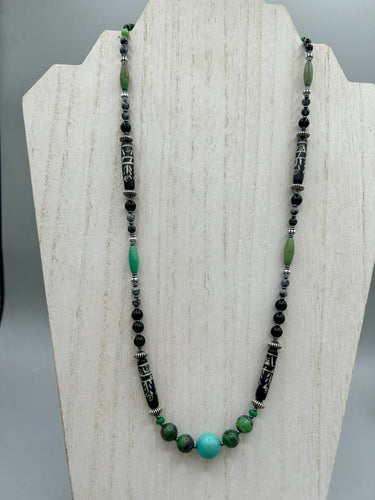 This necklace boasts a diverse selection of natural bead materials, including ruby zoisite, black and snowflake obsidian stones, plus turquoise magnesite, bone, glass and metal beads. This variety of sizes, shapes, textures and colors will make this necklace stand out.    Measurements:  Necklace - 23