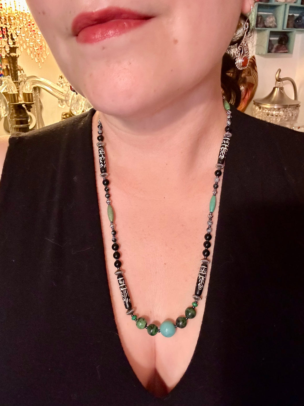 This necklace boasts a diverse selection of natural bead materials, including ruby zoisite, black and snowflake obsidian stones, plus turquoise magnesite, bone, glass and metal beads. This variety of sizes, shapes, textures and colors will make this necklace stand out.    Measurements:  Necklace - 23