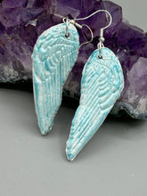 Load image into Gallery viewer, Light baby blue wings earrings made of polymer clay.  These earrings are designed to face forward when worn instead of the front wings showing on the side.
