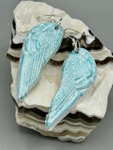 Load image into Gallery viewer, Light baby blue wings earrings made of polymer clay.  These earrings are designed to face forward when worn instead of the front wings showing on the side.

