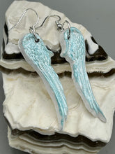 Load image into Gallery viewer, Light baby blue wings earrings made of polymer clay.  These earrings are designed to face forward when worn instead of the front wings showing on the side.
