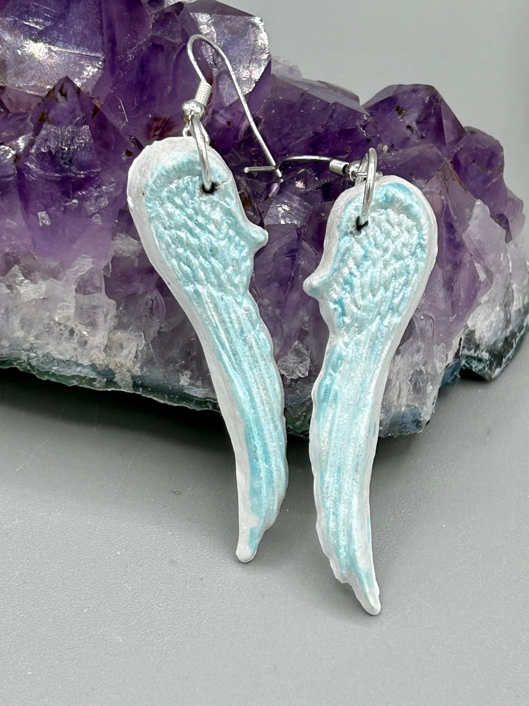 Light baby blue wings earrings made of polymer clay.  These earrings are designed to face forward when worn instead of the front wings showing on the side.