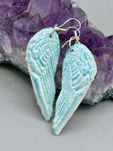 Load image into Gallery viewer, Light baby blue wings earrings made of polymer clay.  These earrings are designed to face forward when worn instead of the front wings showing on the side.
