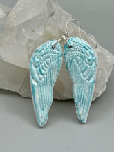 Load image into Gallery viewer, Light baby blue wings earrings made of polymer clay.  These earrings are designed to face forward when worn instead of the front wings showing on the side.

