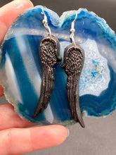 Load image into Gallery viewer, Shimmery black angel wings earrings made of polymer clay.  These earrings are designed to face forward when worn instead of the front wings showing on the side.
