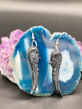 Load image into Gallery viewer, Chrome-colored silver angel wings earrings crafted with polymer clay. Featuring a construction designed to ensure the front wings face forward when worn.
