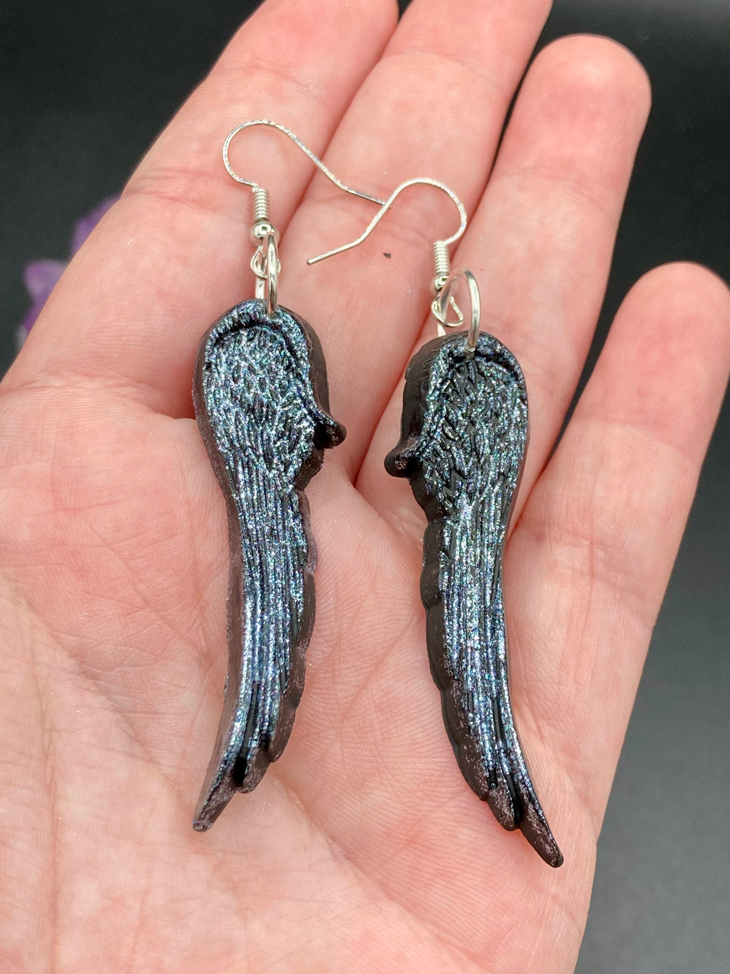 Chrome-colored silver angel wings earrings crafted with polymer clay. Featuring a construction designed to ensure the front wings face forward when worn.