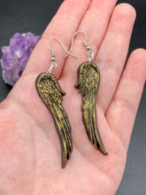 Load image into Gallery viewer, Sparkling gold tone angel wings earrings made of polymer clay.  These earrings are designed to face forward when worn instead of the front wings showing on the side.

