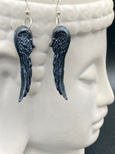Load image into Gallery viewer, Chrome-colored silver angel wings earrings crafted with polymer clay. Featuring a construction designed to ensure the front wings face forward when worn.
