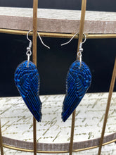 Load image into Gallery viewer, These eye-catching electric blue angel wings earrings are expertly crafted from polymer clay. Featuring an innovative design, they ensure the wings face forward when worn.
