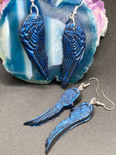 Load image into Gallery viewer, These eye-catching electric blue angel wings earrings are expertly crafted from polymer clay. Featuring an innovative design, they ensure the wings face forward when worn.
