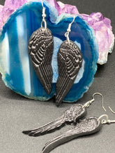 Load image into Gallery viewer, Shimmery black angel wings earrings made of polymer clay.  These earrings are designed to face forward when worn instead of the front wings showing on the side.
