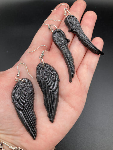 Shimmery black angel wings earrings made of polymer clay.  These earrings are designed to face forward when worn instead of the front wings showing on the side.