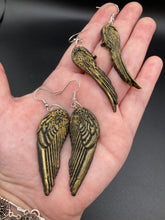 Load image into Gallery viewer, Sparkling gold tone angel wings earrings made of polymer clay.  These earrings are designed to face forward when worn instead of the front wings showing on the side.
