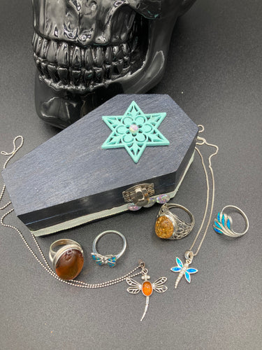 Handmade Vintage Inspired Gothic Victorian Coffin Jewelry Box. Black Wood Coffin Ring Box, Seafoam Blue Star Shape Veneer Floral Embellishment. Dark and whimsical theme keepsake box with dragonfly and shimmer gems. Starry Night Jewelry Box. Interior lined mandala pattern fabric. Holds several rings or jewelry pieces. Dark, Beautiful, Unique Gift for the BOLD. Makes a great keepsake box! Or you could also just let your cat admire it before he knocks it off the table, too.