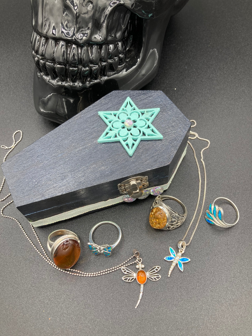 Handmade Vintage Inspired Gothic Victorian Coffin Jewelry Box. Black Wood Coffin Ring Box, Seafoam Blue Star Shape Veneer Floral Embellishment. Dark and whimsical theme keepsake box with dragonfly and shimmer gems. Starry Night Jewelry Box. Interior lined mandala pattern fabric. Holds several rings or jewelry pieces. Dark, Beautiful, Unique Gift for the BOLD. Makes a great keepsake box! Or you could also just let your cat admire it before he knocks it off the table, too.