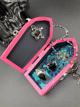 Load image into Gallery viewer, This unique handmade Pink Spooky Glam Wood Coffin Ring Box offers a statement piece for your witchy home decor. Its macabre collections boast a black and pink wood coffin with large shimmery bat embellishments and decorative black crystals around the exterior. Open up the box to find a bright turquoise mandala fabric and a tiny black crystal bat decoration for a truly eerie feel.
