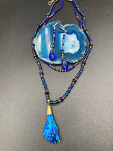 Load image into Gallery viewer, This stunning, one of a kind pair of celestial beaded earrings is a bold addition to any jewelry collection. Crafted with vibrant blue glass beads, the color contains varied shades of blue, purple, and hints of gold to create unique texture. The design is inspired by the awe-inspiring beauty of the majestic galaxy.  Measurements: 2 3/4 ” in length
