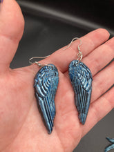 Load image into Gallery viewer, Sparkling light blue angel wings earrings made of polymer clay.  These earrings are designed to face forward when worn instead of the front wings showing on the side.
