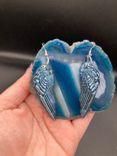Load image into Gallery viewer, Sparkling light blue angel wings earrings made of polymer clay.  These earrings are designed to face forward when worn instead of the front wings showing on the side.

