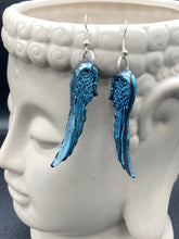 Load image into Gallery viewer, Sparkling light blue angel wings earrings made of polymer clay.  These earrings are designed to face forward when worn instead of the front wings showing on the side.
