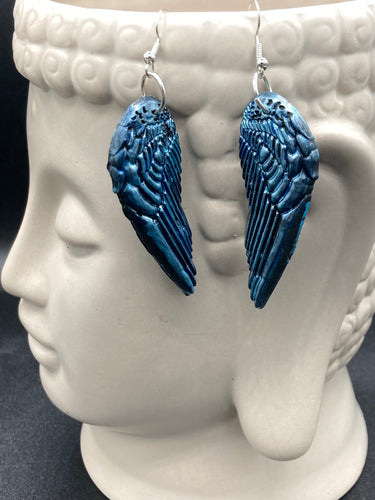 Sparkling light blue angel wings earrings made of polymer clay.  These earrings are designed to face forward when worn instead of the front wings showing on the side.