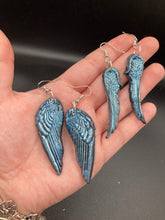 Load image into Gallery viewer, Sparkling light blue angel wings earrings made of polymer clay.  These earrings are designed to face forward when worn instead of the front wings showing on the side.
