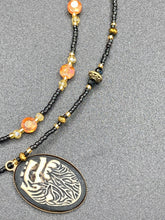 Load image into Gallery viewer, This spooky resin anatomical heart pendant is too cute!!! The pendant is made of resin with brass metal backing. An assortment of floral metal beads to give it a contrast to the soft, dainty style of the glass beaded necklace. Tiny shimmer black glass beads with yellow and orange glass beads to give it a pop of color.  Necklace measures 16” adjustable up to 18” in length, pendant is 1 1/4” Height

