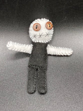 Load image into Gallery viewer,  Skinny black and white Voodoo Doll stands at 3 7/8&quot; in height. Black torso and legs with white arm and head.  Stylish brown buttons for eyes, but his lips are sowed shut of course.
