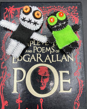Load image into Gallery viewer, Black and white Voodoo Doll stand at 3 3/4&quot; in height.  He has a black torso with white arms and legs, and a big round white head.  Bulging yellow/orange buttons for eye and his mouth is sowed shut but despite that he kinda looks like he’s smiling.  Tiny black and lime green Voodoo Doll stands at 3&quot; in height. He has a lime green torso but the rest is black.  He has a tiny round head with tiny orange buttons for eyes which makes him look cute.  His mouth is sowed shut of course.
