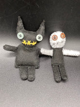 Load image into Gallery viewer,  Skinny black and white Voodoo Doll stands at 3 7/8&quot; in height. Black torso and legs with white arm and head.  Stylish brown buttons for eyes, but his lips are sowed shut of course.  Black Devil Voodoo Doll has yellow mouth and cute little black horns of course, white buttons for eyes: 3 3/8&quot; in height.
